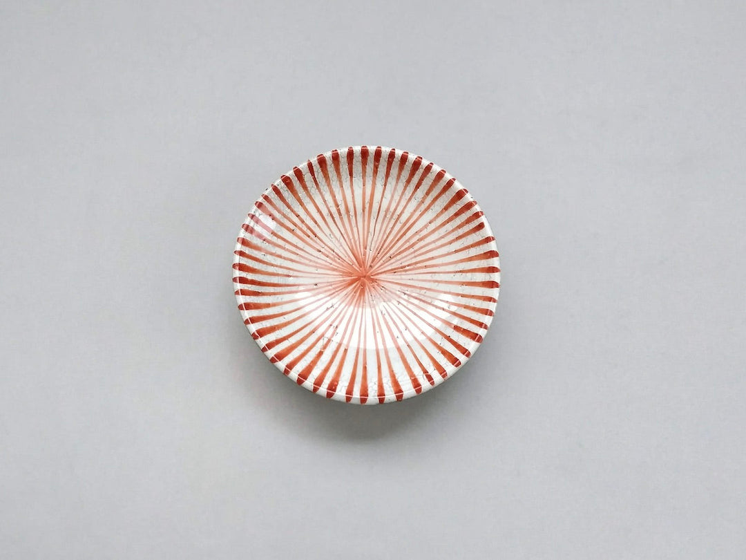 A red and white plate with a slip tokusa ridged pattern