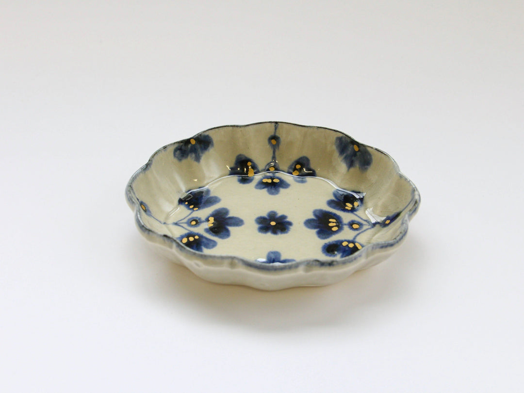A gray plate with a wavy rim and a gold-coloured flower pattern