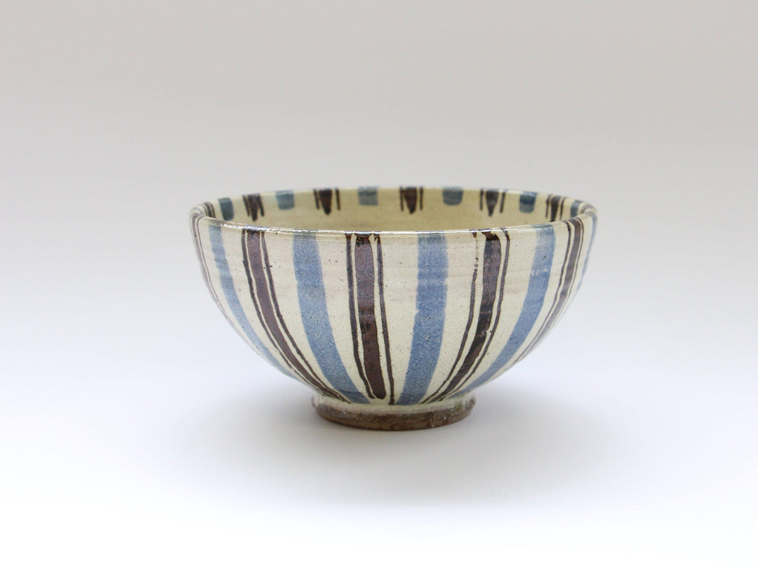 A deep blue bowl covered in white slip with fine iron lines