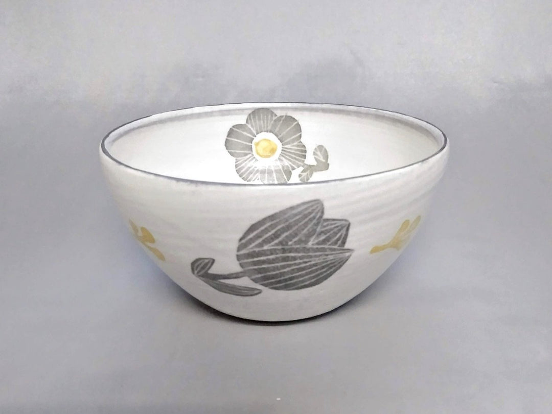 A deep bowl with an underglazed gray and yellow flower pattern
