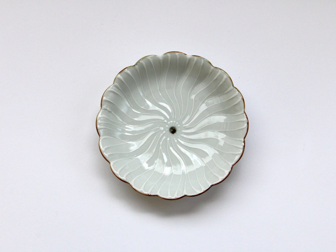 A white porcelain plate with a petal flower raised in slip