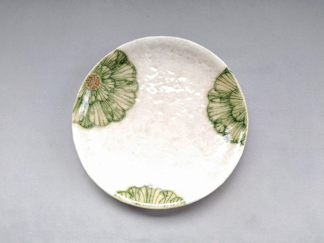 A green round plate with a peony drawn in white slip